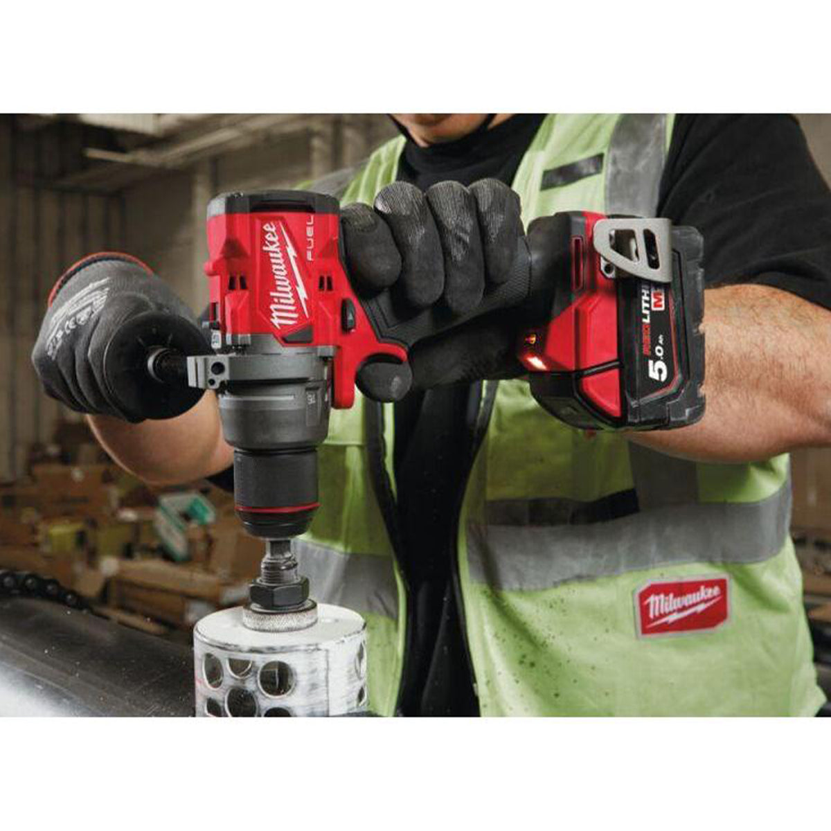 Person using Milwaukee power tools in a workshop setting