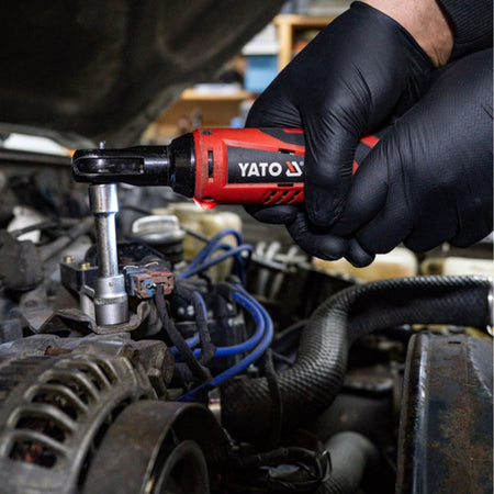 Person using a YATO impact wrench on a car engine