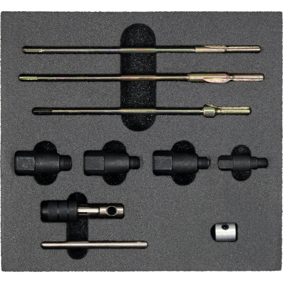 Set of drill bits and related tools on a gray foam block